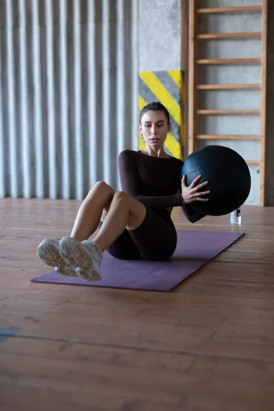 Woman doing her abs with a medicine ball — Stok fotoğraf