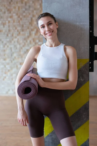 Retrato de una mujer con esterilla de yoga lista para practicar —  Fotos de Stock