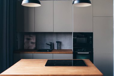 Modern kitchen with table and built-in hob. Interior design