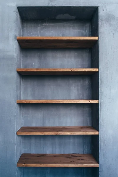 Empty wood shelves at concrete wall in home interior. — Stock fotografie