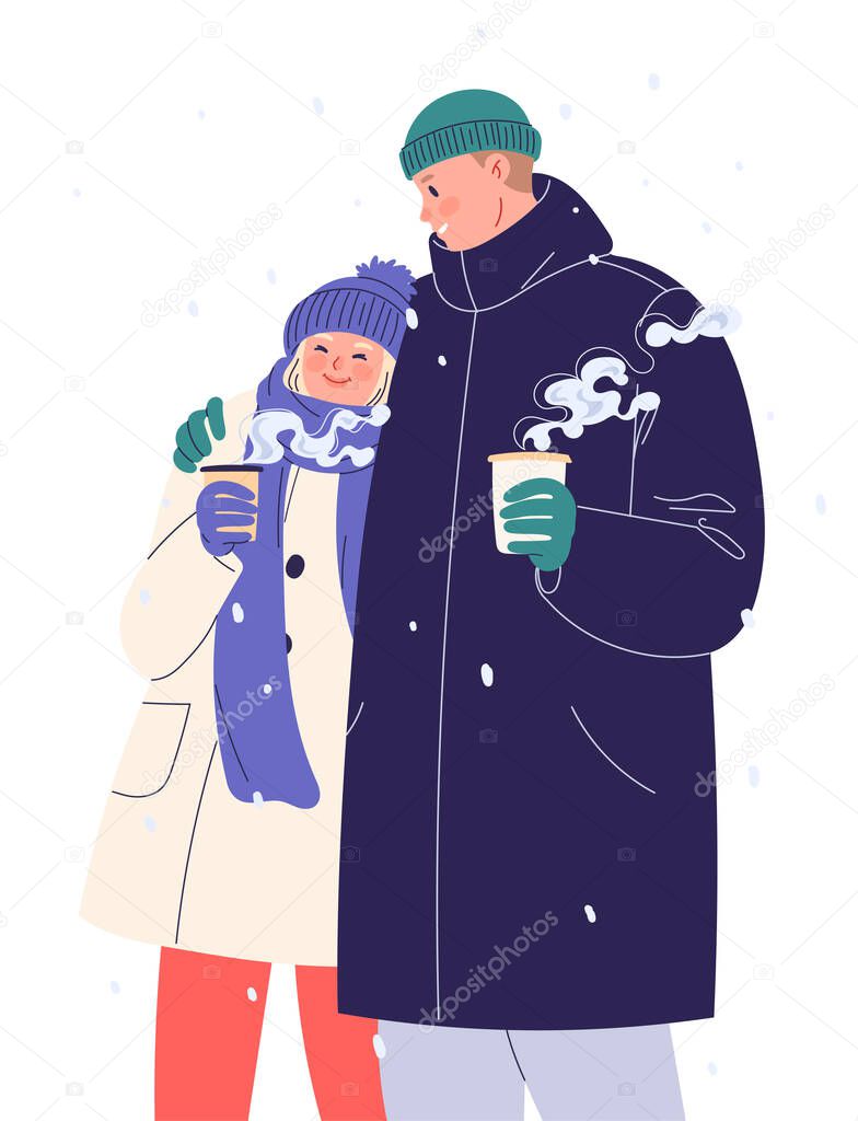 Happy young couple walking in winter and drinking coffee