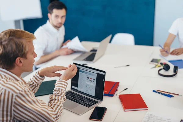 Une équipe de personnes se réunit au travail tout en étant assis à la table de conférence — Photo