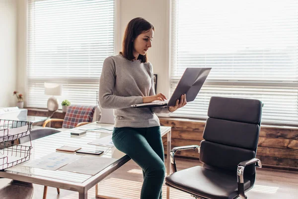 Kvinna på kontoret på arbetsplatsen med bärbar dator — Stockfoto