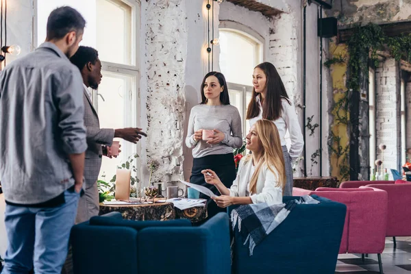 Groep mensen verzameld rond tafel tijdens de pauze in een coffeeshop — Stockfoto