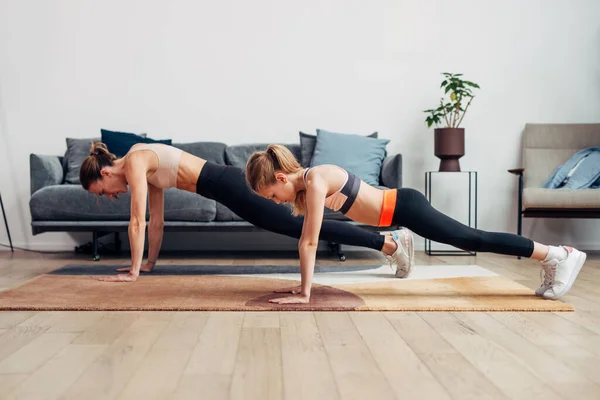 Moeder en dochter trainen thuis, doen push-ups — Stockfoto