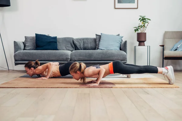 Mãe e filha trabalhando em casa, fazendo flexões — Fotografia de Stock