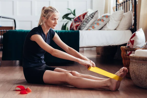 Frau trainiert zu Hause mit Gummiband. — Stockfoto