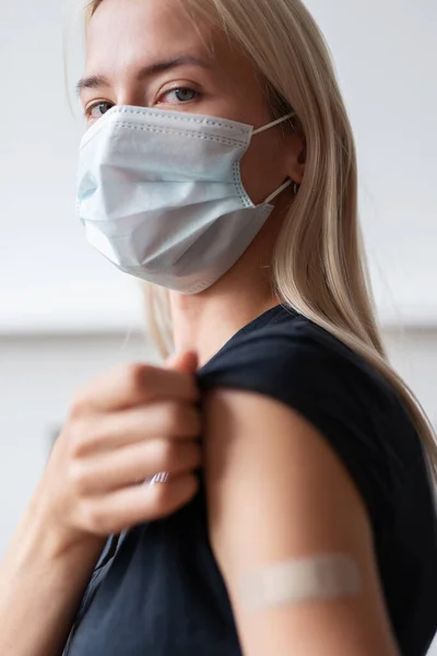 Žena držící si rukáv košile po očkování — Stock fotografie