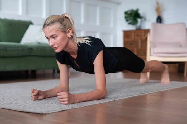 Žena dělá prkno cvičení doma — Stock fotografie