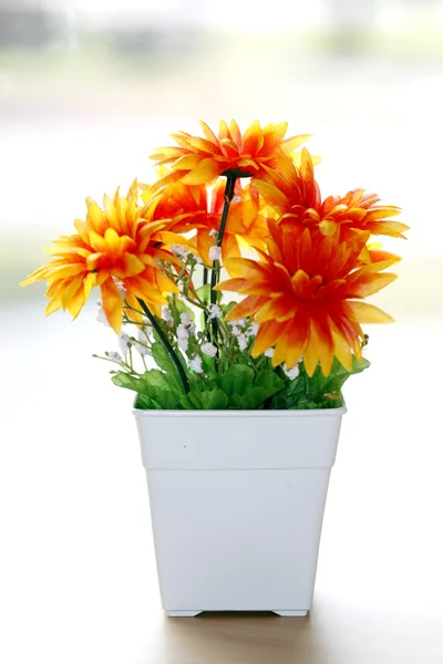 Colorido es naranja flores en un jarrón blanco . — Foto de Stock