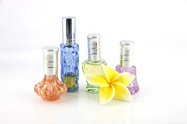 The yellow flowers and Orange,Blue,Green,Violet Perfume bottles. — Stock Photo, Image