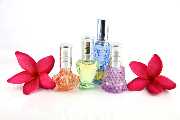 The Red flowers and Orange,Blue,Green,Violet Perfume bottles. — Stock Photo, Image