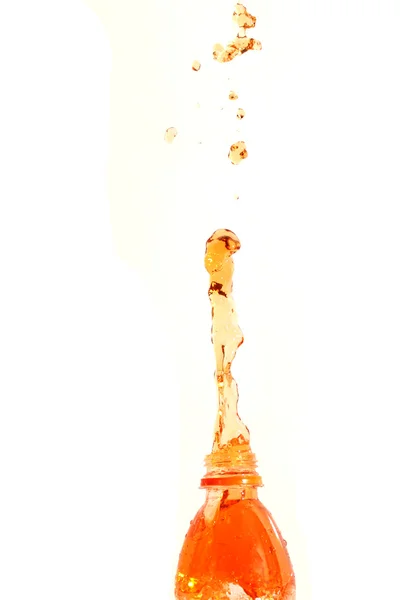 Pomerančová šťáva, která se šíří z láhve. — Stock fotografie