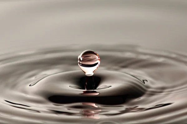 Water drop close up into a beautiful shape. — Stock Photo, Image