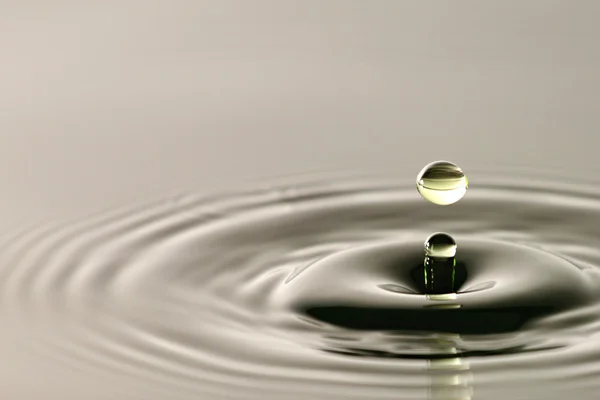 Water drop close up into a beautiful shape. — Stock Photo, Image