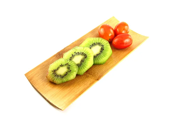 Kiwifruit slices into pieces and three Tomato. — Stock Photo, Image