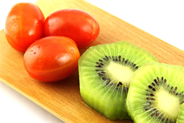 Kiwi's segmenten in stukken en drie tomaat. — Stockfoto