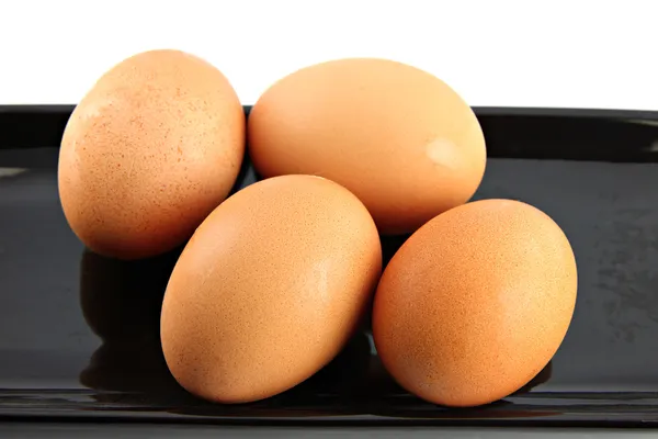 Chicken eggs on black dish. — Stock Photo, Image