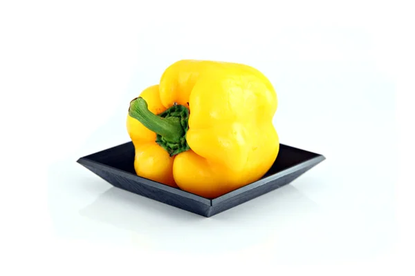 Κίτρινη πιπεριά στο μαύρο πιάτο. — Φωτογραφία Αρχείου
