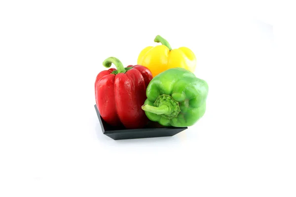 Drie kleur van paprika in een zwarte schotel. — Stockfoto