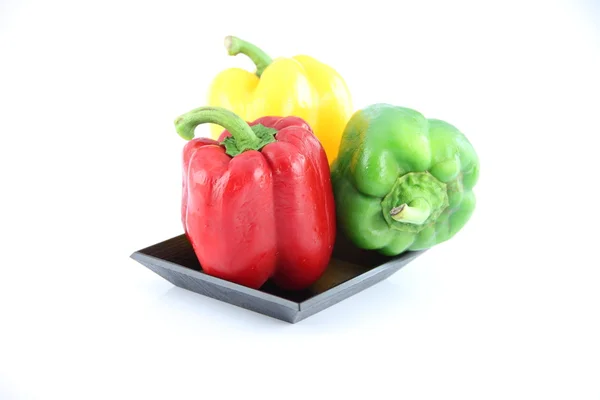 Drie kleur van paprika in een zwarte schotel. — Stockfoto