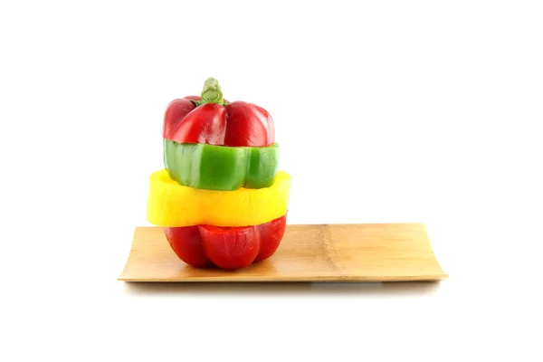 Die drei Farben der Paprika in senkrecht angeordnete Scheiben schneiden. — Stockfoto