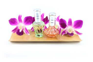 Bambu tabak içinde mor orkide ve parfüm şişeleri