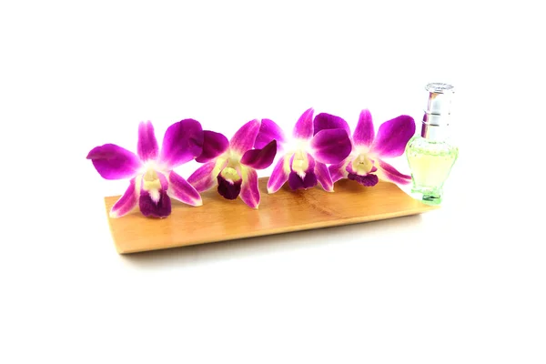 Purple orchid and perfume bottles in bamboo dish — Stock Photo, Image