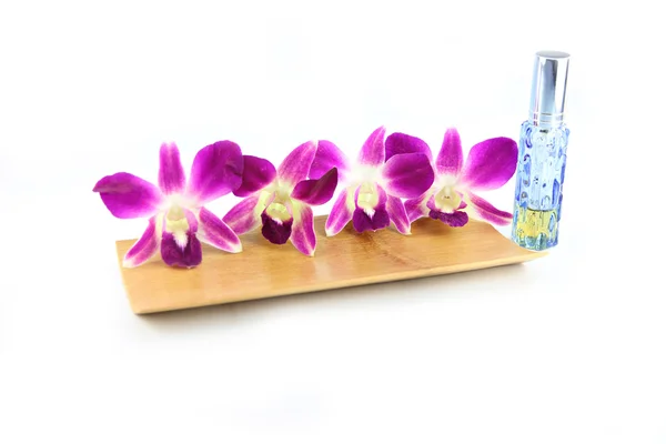 Purple orchid and perfume bottles in bamboo dish — Stock Photo, Image