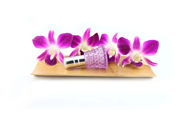 Purple orchid and perfume bottles in bamboo dish — Stock Photo, Image