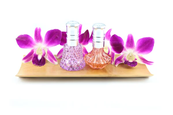 Фиолетовая орхидея и парфюмерные бутылки в бамбуковой тарелке — стоковое фото