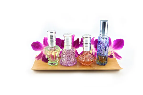 Purple orchid and perfume bottles in bamboo dish — Stock Photo, Image