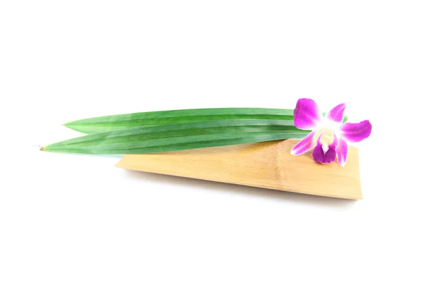 Purple orchids and pandanus in bamboo dish. — Stock Photo, Image