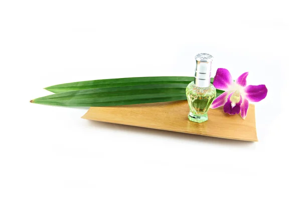 Perfume bottles,Purple orchids and pandanus in bamboo dish. — Stock Photo, Image