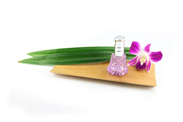 Perfume bottles,Purple orchids and pandanus in bamboo dish. — Stock Photo, Image