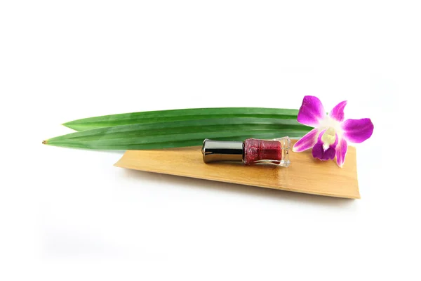 Perfume bottles,Purple orchids and pandanus in bamboo dish. — Stock Photo, Image