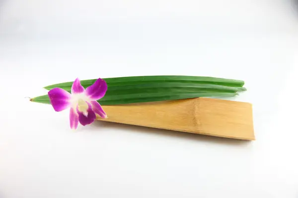 Orquídeas púrpuras y pandanus en plato de bambú . — Foto de Stock
