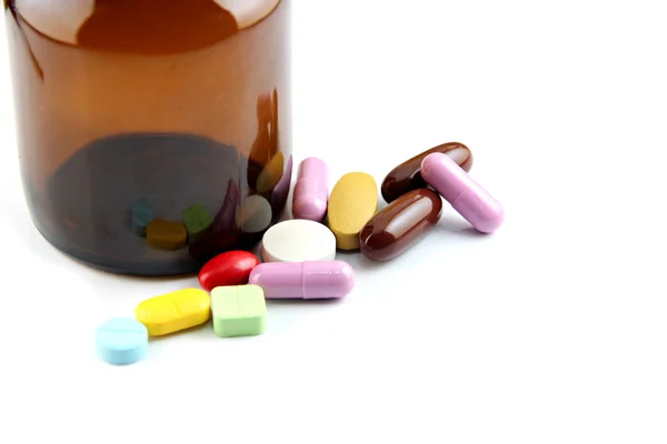Pille mit vielen Farben neben der Flasche. — Stockfoto