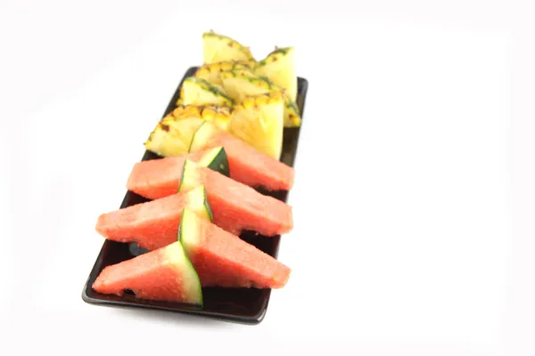 Ananas och vattenmelon slice ordnade i svarta skålen. — Stockfoto