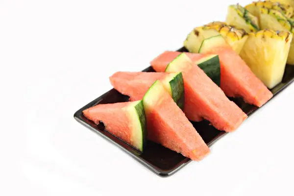 Ananas och vattenmelon slice ordnade i svarta skålen. — Stockfoto