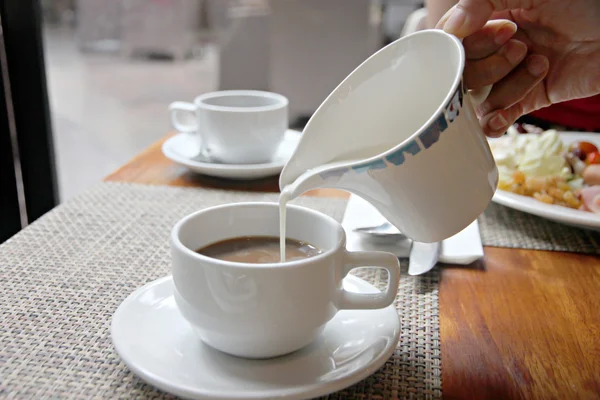Verter leche en la taza de café. — Foto de Stock