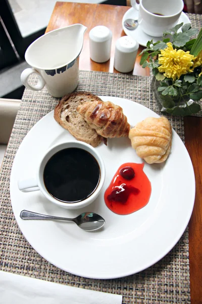Kaffe, bröd och sylt i vit skål. — Stockfoto