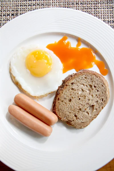 Œufs, pain grillé et saucisse dans un plat blanc . — Photo