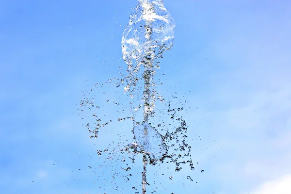 Water is wijd verspreid over een blauwe achtergrond. — Stockfoto