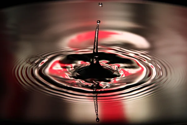 Bilder vatten droppar en vacker form på röda och vita ba — Stockfoto