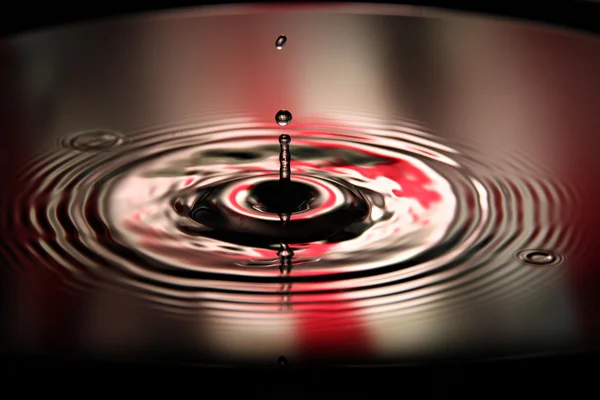 Képek a két víz csepp piros és ír háttér. — Stock Fotó