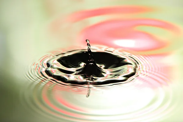 Imagens de água cai uma forma bonita no fundo colorido . — Fotografia de Stock