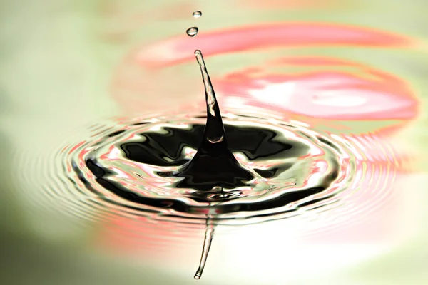 Bilder Wassertropfen eine schöne Form auf buntem Hintergrund. — Stockfoto