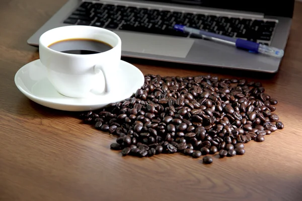 Közeli a számítógép notebook fehér csésze kávé. — Stock Fotó