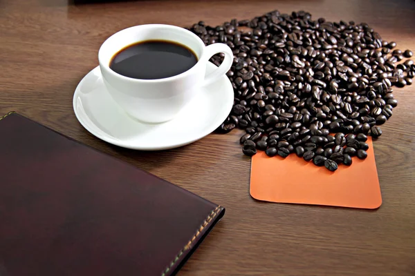 Weiße Kaffeetasse und Computer auf Holztisch und Notizbuch — Stockfoto